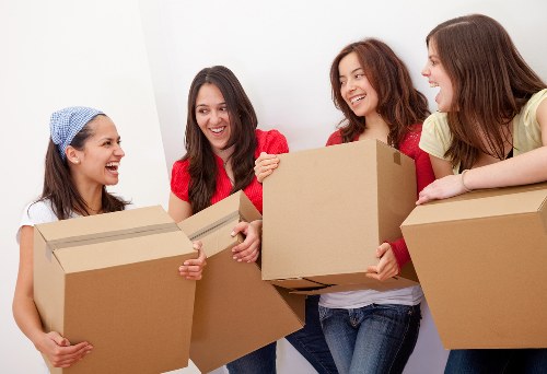 Professional movers unloading household items at a new property